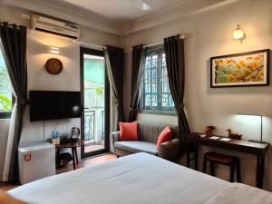 a hotel room with a bed and a tv at T Home Balcony in Hanoi