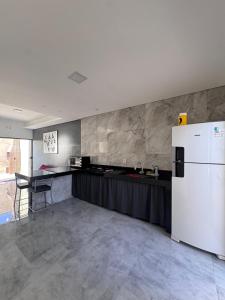 a kitchen with a white refrigerator and a table at Casa Hospedagem e Temporada Mobiliada in Sete Lagoas