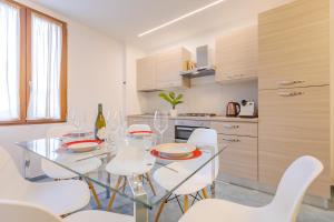 a kitchen with a glass table and white chairs at L'Acqua e la Pietra in Rapolano Terme