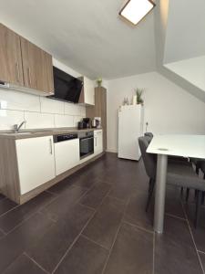 a kitchen with a table and a white refrigerator at Schönes Zimmer im Zentrum - 2 in Paderborn