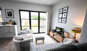 a living room with two chairs and a television at Hythe House in Hythe
