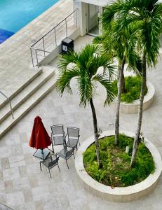 a table and chairs in a courtyard with palm trees at Vista Marina Boca Chica in Boca Chica