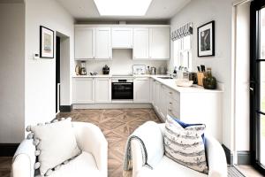 a kitchen with white cabinets and a white couch at Hythe House in Hythe
