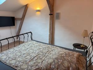 a bedroom with a bed and a flat screen tv at Speicherstübchen im alten Speicher in Schönberg