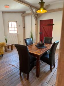 a dining room with a wooden table and chairs at Speicherstübchen im alten Speicher in Schönberg
