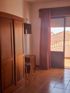 a room with a dresser and a window with a view at Residência Livramento in Velas