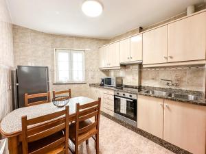 a kitchen with a table and chairs and a refrigerator at Apartamento Brisa by ALÔGA in Corcubión +6 photos