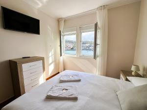 a bedroom with a bed with two towels on it at Apartamento Brisa by ALÔGA in Corcubión