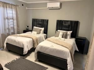 a bedroom with two beds and a air conditioner at Florino GuestHouse in Rundu