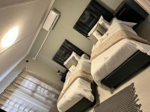 a bedroom with two beds with white pillows at Florino GuestHouse in Rundu