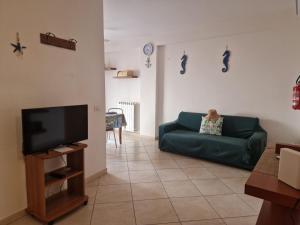 a living room with a green couch and a tv at Cavalluccio Marino-Central-with Balcony by Gessica Holiday in Polignano a Mare