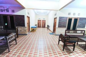 a hallway with benches and tables in a room at Penginapan Barokah in Kemadang +38 photos