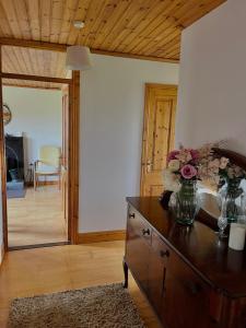 a living room with a table with a vase of flowers on it at Beautiful Beach Side Bungalow in Galway