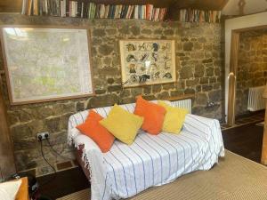 a room with a bed with colorful pillows on it at Secluded 17th Century converted barn in Midhurst