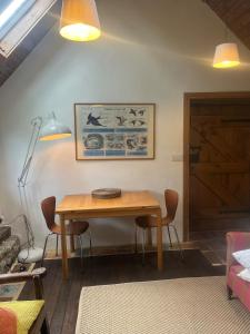 a dining room with a wooden table and two chairs at Secluded 17th Century converted barn in Midhurst
