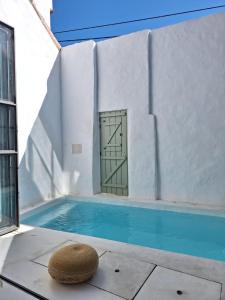 a house with a swimming pool with a door at Casa do Capitão in Monte Trigo