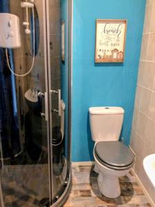 a bathroom with a toilet and a shower at Commodore Guesthouse, Seaside Holiday Suites in Rothesay +32 photos