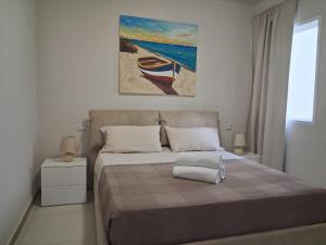 a bedroom with a bed with a painting on the wall at KatlantiK Beach House Deluxe in Sal Rei