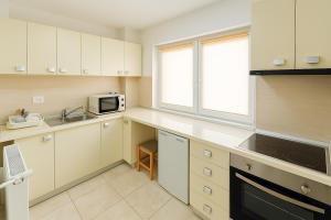 a kitchen with white cabinets and a microwave at Nicolle Cozy Apartment in Piteşti +1 photo