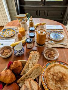 a table topped with plates of bread and croissants at Maison Loire et Mer in Mer +26 photos