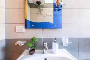 a bathroom sink with a blue cabinet above it at Shiny 2 Central Stay in Himare +8 photos