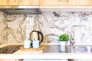 a kitchen counter with two mugs and a sink at Shiny 2 Central Stay in Himare