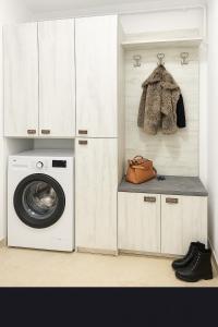 a laundry room with a washer and a washing machine at Nicolle Cozy Apartment in Piteşti