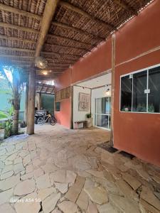 a room with a stone floor and a red wall at Alma Surf House in Boicucanga +13 photos