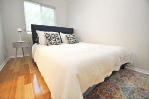 a bedroom with a white bed with pillows and a window at The Austin Cool Condo in Austin