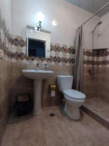 a bathroom with a toilet and a sink and a shower at Sunny Hotel in Kobuleti
