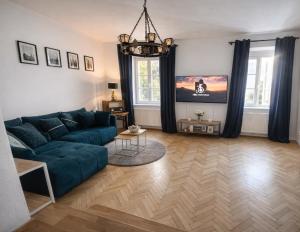 a living room with a blue couch and a chandelier at Štúr Apartment Michalská in Bratislava