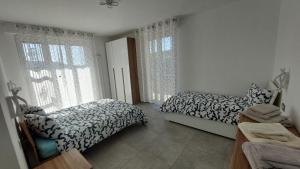 a bedroom with two beds and a window at La Pineta, 26 - 3 in Casarza Ligure