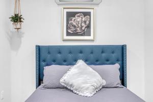 a bed with a blue headboard and a pillow at The Container Retreat - 7A.. in Canyon Lake