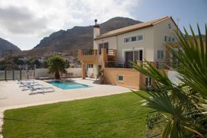 a villa with a swimming pool and mountains in the background at Villa Frati Gorge in Fratíon