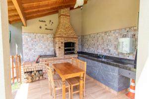 a kitchen with a wooden table and a fireplace at Pousada das Bandeiras in Olímpia
