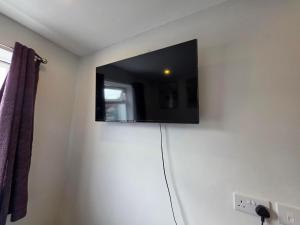 a flat screen tv on the wall of a room at Zesty Zen in Thornton Heath