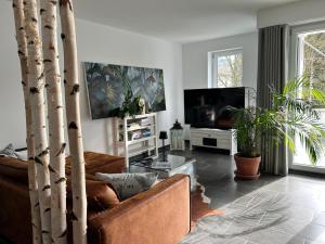 a living room with a couch and a tv at Cube - Ferienhaus mit Garten und Terrasse in Eberbach in Eberbach