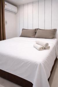 a large white bed with two towels on it at Litorânea Top View ' Beira Mar ' 15 Hospedes in São Luís