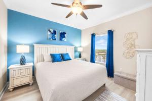 a bedroom with a bed with blue walls and a ceiling fan at Splash Resort Luxury Pools Lazy River Water Parks Sept still Available in Panama City Beach