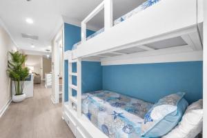 a bedroom with two bunk beds and a blue wall at Splash Resort Luxury Pools Lazy River Water Parks Sept still Available in Panama City Beach