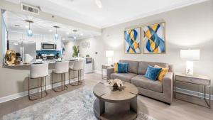a living room and kitchen with a couch and a table at Splash Resort Luxury Pools Lazy River Water Parks Sept still Available in Panama City Beach +37 photos