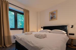 a bedroom with a large white bed with towels on it at Tramontana Iž in Veli Iž