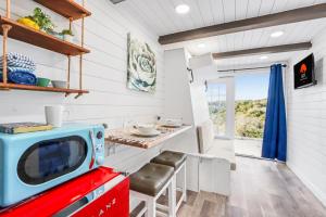 a kitchen with a red and blue tv on a counter at The Container Retreat - C10 in Canyon Lake