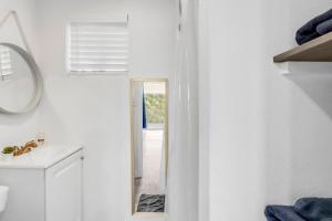 a white bathroom with a mirror and a sink at The Container Retreat - C10 in Canyon Lake