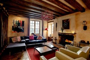 a living room with couches and a fireplace at Cité Plantagenêt, Jardin & piscine 24H du Mans in Le Mans