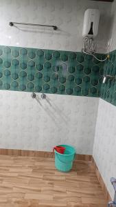 a bathroom with a green and white tiled wall at Sakchi Gopal Ashram in Vrindāvan +6 photos