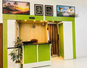 an office lobby with a green and white reception desk at Amada Family Guest House in Karachi
