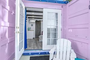 a pink house with a white door and a doorway at The Container Retreat - C11.. in Canyon Lake