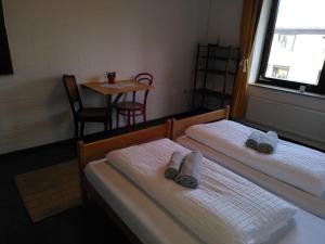 two beds in a room with a small table and a tableablishthritisthritisthritis at Zimmer 12 in Gomadingen