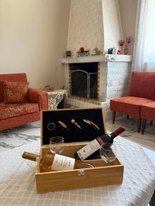a box of wine bottles and glasses on a table in a living room at Anastasia's House Kos in Marmaroto